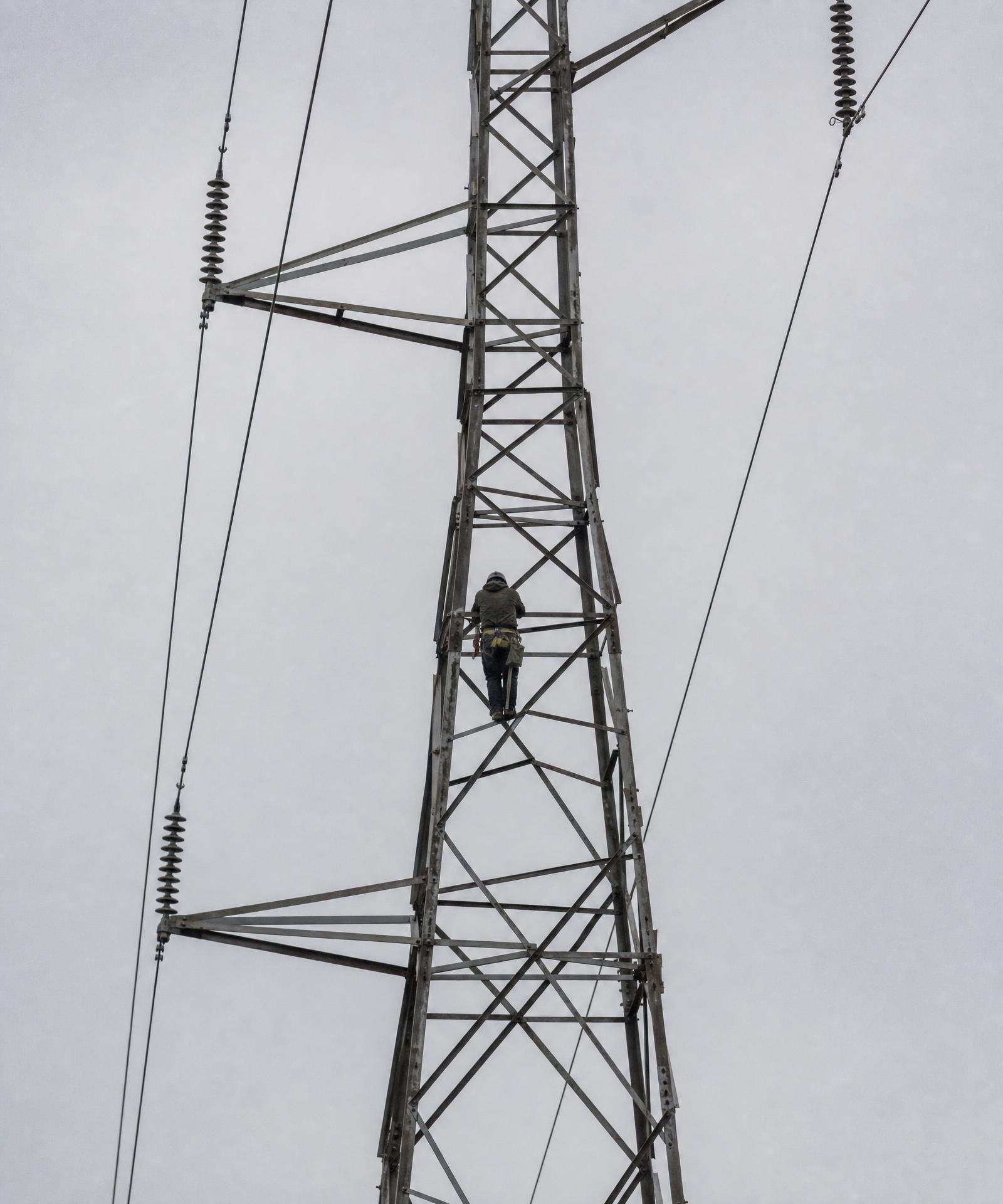 Transmission lineman working on high-voltage equipment